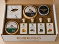 Caja Ricoroso abierta con el Lote La Tabla: quesos de cabra Trufante, Montebajo y Suculento, crema de queso azul con ajo negro y cuatro aceites aromatizados.